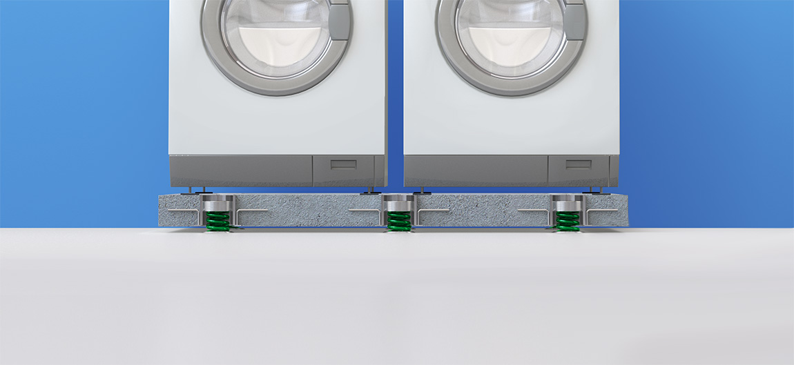 An image of Vibratecs VT-JFS solution for washing machines. The solution shows how the springs suspend the concrete slab above the floor and isolates the vibrations created by the washing machines mounted on top of the slab.