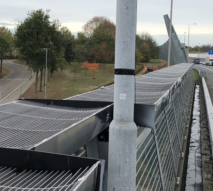 WHIS topp, a traffic noise diffractor, installed on an existing barrier at an overpass for better noise reduction.